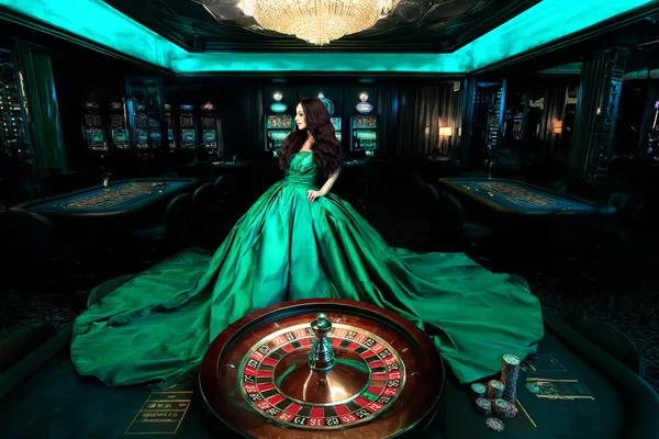 A woman smiling by bright slot machines showing lucky symbols, showcasing the exciting slot offerings at AMJILI.