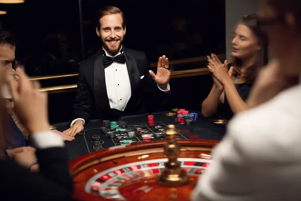 A confident dealer surrounded by casino chips inviting players to access their AMJILI account, reflecting quick and easy login options.